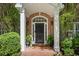 Elegant front entrance with brick columns, a black front door, and lush landscaping creating a welcoming curb appeal at 4470 Crestwicke Pointe, Atlanta, GA 30319