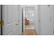 Hallway leading to a bathroom featuring an ornate chair, tiled floor, and window with shutters at 4470 Crestwicke Pointe, Atlanta, GA 30319