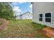 View of a green backyard with grass and landscaping, next to the home's light colored siding at 74 Macland Mill Ln, Dallas, GA 30157