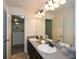 Bathroom with granite counters, double sinks, and modern lighting fixtures over large vanity mirror at 74 Macland Mill Ln, Dallas, GA 30157