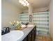 Well-lit bathroom features double sinks, granite counters, and a shower/tub combo with a striped curtain at 74 Macland Mill Ln, Dallas, GA 30157