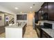 Well-lit kitchen with granite countertops, dark wood cabinets, and stainless steel appliances at 74 Macland Mill Ln, Dallas, GA 30157