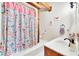 Bright bathroom with a colorful shower curtain, white tile floor, and wood vanity at 800 Knox Ln, Canton, GA 30114