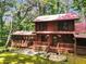 Charming log cabin with a red roof and a screened porch, nestled among lush greenery at 800 Knox Ln, Canton, GA 30114