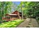 Stunning log home with a red roof, nestled in the woods with a stone and gravel walkway at 800 Knox Ln, Canton, GA 30114