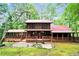 Charming log home with a red metal roof, spacious porch and screened in porch surrounded by mature trees at 800 Knox Ln, Canton, GA 30114