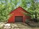 Red log cabin style garage, perfect for storage and vehicles, surrounded by lush greenery at 800 Knox Ln, Canton, GA 30114