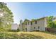 Exterior view of the home's backyard with lush grass, trees, and clear skies at 2130 Boulder Gate Dr, Ellenwood, GA 30294