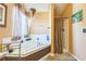 Bathroom with a large white tub, shower, decorative light fixture and neutral walls at 2130 Boulder Gate Dr, Ellenwood, GA 30294