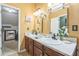 Bathroom with double sinks, decorative mirrors, and neutral colored walls at 2130 Boulder Gate Dr, Ellenwood, GA 30294