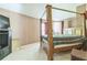 Cozy bedroom showcasing a four-poster bed, TV, and a window with natural light at 2130 Boulder Gate Dr, Ellenwood, GA 30294