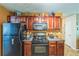 Kitchen features black appliances, wood cabinets, and stone countertops at 2130 Boulder Gate Dr, Ellenwood, GA 30294