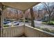 Covered patio with lattice railing, views of parking area and wooded hillside at 505 Bainbridge Dr, Atlanta, GA 30327