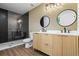 Modern bathroom with double vanity, decorative mirrors, and a glass-enclosed black tiled shower at 1111 Edgefield Sw Dr, Atlanta, GA 30310