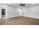 Minimalist bedroom with wood floors, ceiling fan, white walls and a doorway to the ensuite bath at 1111 Edgefield Sw Dr, Atlanta, GA 30310
