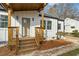 Charming front entrance featuring a wooden porch, white siding and modern light fixtures at 1111 Edgefield Sw Dr, Atlanta, GA 30310