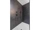 Close-up of modern shower featuring dark grey hexagon tiles, black fixtures and white shower floor at 1111 Edgefield Sw Dr, Atlanta, GA 30310