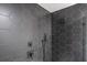 Close-up of shower featuring dark grey hexagon tiles, black fixtures and glass doors at 1111 Edgefield Sw Dr, Atlanta, GA 30310