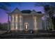 Stately two-story home featuring a covered porch supported by grand columns, illuminated at twilight at 119 E Johnson St, Temple, GA 30179