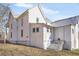 Rear exterior view with white wood siding, metal roof, and inviting stone steps at 119 E Johnson St, Temple, GA 30179