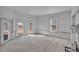A sun-lit living room features several large windows, white walls and potential for customization at 119 E Johnson St, Temple, GA 30179