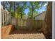 Fenced backyard with a brick garden, tree, and a grassy area perfect for outdoor activities at 3326 Northcrest Rd # C, Atlanta, GA 30340