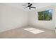 Empty bedroom featuring neutral walls, carpet, ceiling fan, and natural light from the large window at 3326 Northcrest Rd # C, Atlanta, GA 30340