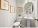 Charming powder room featuring a pedestal sink and decorative artwork at 877 Pensive Run, Dacula, GA 30019