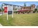 Alcovey Meadows entrance featuring townhomes and signage with a 'Now Selling' sign at 877 Pensive Run, Dacula, GA 30019