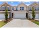 Charming townhouse showcasing a brick and siding exterior with a two-car garage and a well-manicured lawn at 877 Pensive Run, Dacula, GA 30019
