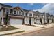 Several townhouses with brick and siding, attached garages, and landscaping define this picturesque community at 877 Pensive Run, Dacula, GA 30019