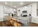 Bright kitchen boasts granite countertops, stainless appliances, gray cabinetry, and an island with bar seating at 877 Pensive Run, Dacula, GA 30019
