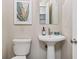 A charming powder room includes a pedestal sink, toilet, and neutral walls at 1299 Dunwoody Cv, Atlanta, GA 30338
