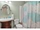 Classic bathroom featuring a wood vanity, round mirror, and shower/tub combo with a decorative curtain at 1299 Dunwoody Cv, Atlanta, GA 30338