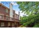View of brick townhouse exterior with balconies, chimneys, and tree in view at 1299 Dunwoody Cv, Atlanta, GA 30338
