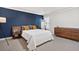 Stylish main bedroom with blue accent wall, complemented by light-colored walls and wooden furniture at 1299 Dunwoody Cv, Atlanta, GA 30338