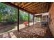 View of the brick patio under the deck with wood beams and small landscaped area at 1299 Dunwoody Cv, Atlanta, GA 30338