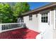 This outdoor space features a red wooden porch with a white door and railings at 140 Maplewood Dr, Temple, GA 30179