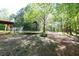 Expansive backyard with lush greenery, featuring a trampoline and deck; perfect for Gathering activities and relaxing at 140 Maplewood Dr, Temple, GA 30179