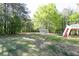 Spacious backyard featuring mature trees, lush lawn, and a charming deck with stairs, perfect for outdoor enjoyment at 140 Maplewood Dr, Temple, GA 30179