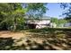 Lush backyard featuring mature trees, a patio, and home with a deck, creating a serene outdoor space at 140 Maplewood Dr, Temple, GA 30179