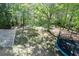 Large backyard with mature trees, lawn, and trampoline, offering a private and serene outdoor space at 140 Maplewood Dr, Temple, GA 30179