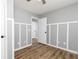 Bedroom featuring wood-look flooring, modern chair rail trim, and hallway access at 140 Maplewood Dr, Temple, GA 30179