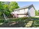 Well-maintained home exterior featuring a deck with stairs, set on a spacious lawn with mature trees at 140 Maplewood Dr, Temple, GA 30179