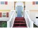 Close-up of the front door entrance, with white railings and brick steps leading up at 140 Maplewood Dr, Temple, GA 30179