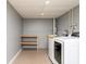 This laundry room features modern machines, shelving and neutral colors at 140 Maplewood Dr, Temple, GA 30179