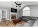 Cozy living room featuring a brick fireplace, hardwood floors, and a comfortable leather sectional sofa at 140 Maplewood Dr, Temple, GA 30179