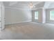 Spacious bedroom with tray ceiling, a fan, neutral carpet, and natural light at 1821 Silver Crest Way, Hoschton, GA 30548