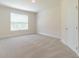 Bright bedroom featuring neutral carpeting and natural light from a large window at 1821 Silver Crest Way, Hoschton, GA 30548