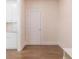 Neutral hallway features hardwood floors and access to a kitchen and utility door at 1821 Silver Crest Way, Hoschton, GA 30548